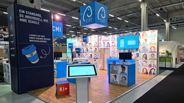 Ein Messestand mit interaktiven Displays und illustrationsreichen Wänden.