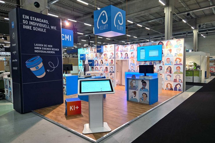 Ein Messestand mit interaktiven Displays und illustrationsreichen Wänden.