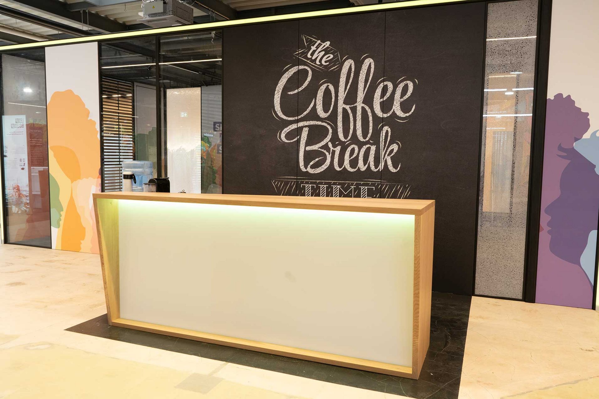 Ein Empfangstresen mit einer Wandbeschriftung für "Kaffeepause".