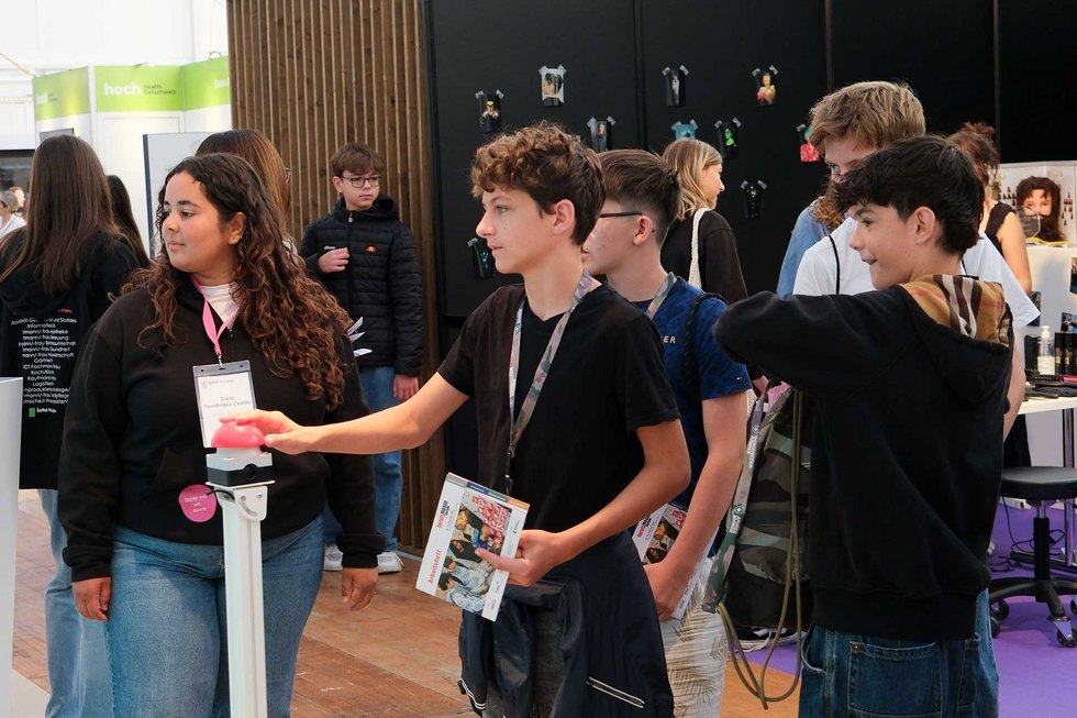 Passion Eine Gruppe junger Menschen interagiert an einem Stand.