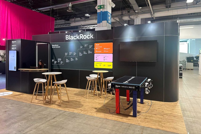 Ein Messestand von BlackRock mit Möbeln und Informationsmaterial.