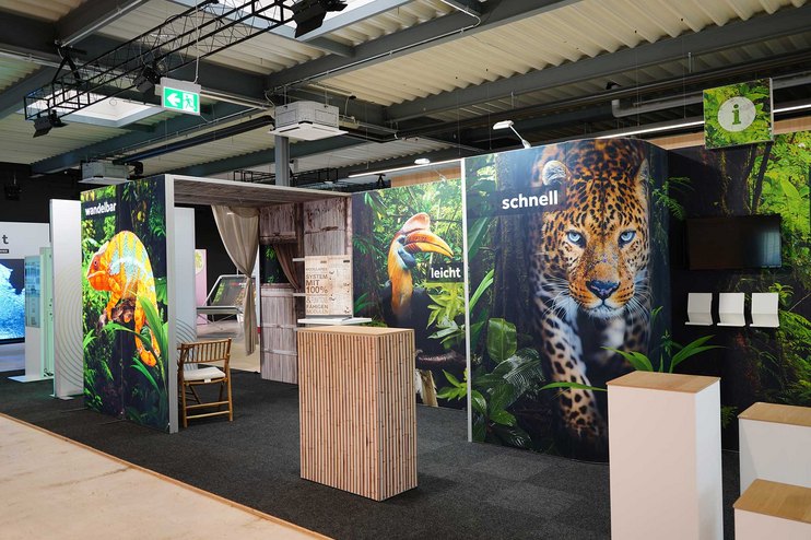 Ein Messestand mit Dschungelmotiven und einer Theke.