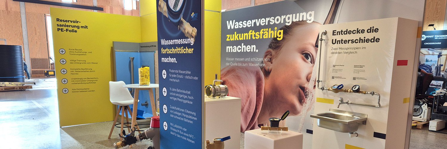 Ein Messestand für Wassertechnik mit verschiedenen Wasserzählern und einem Waschbecken.