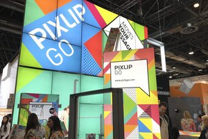 Farbenfroher Messestand mit beleuchteten Displaywänden und Besuchern