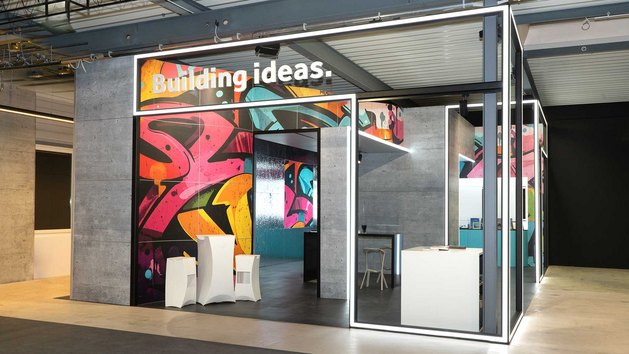 Ein modern gestalteter Raum mit bunten Wänden und verschiedenen Bereichen.