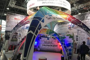 Farbenfrohes aufblasbares Event-Zelt auf einer Messe mit Werbeplakaten und Informationsdisplays.