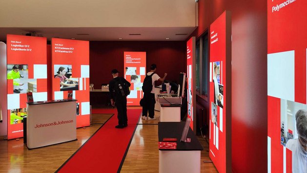 Ein Messestand von Johnson & Johnson mit Informationsständen und Besuchern.