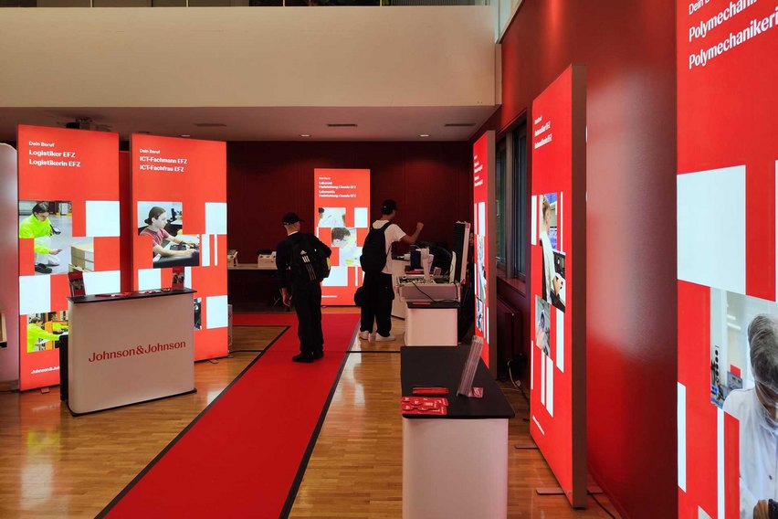 Ein Messestand von Johnson & Johnson mit Informationsständen und Besuchern.