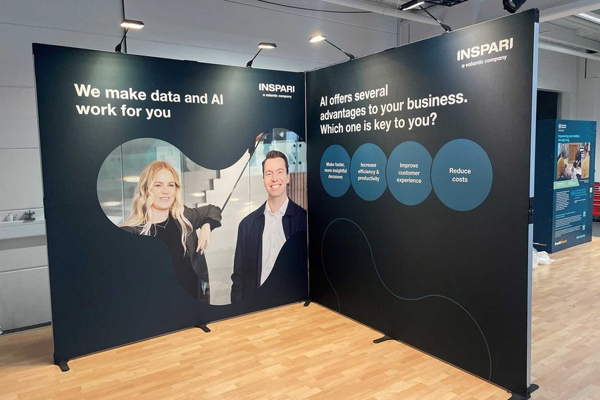 Ein Messestand mit Grafiken zu Daten- und KI-Lösungen für Unternehmen.