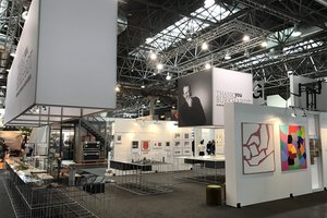 Professioneller Messestand mit hängenden Werbetafeln und Ausstellungsvitrinen