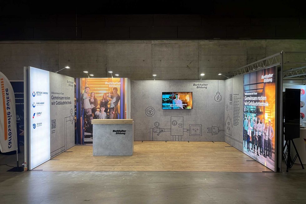 Burkhalter Bildungsstand Ein Messestand von Burkhalter Bildung mit einem Empfangstresen und Informationswänden.