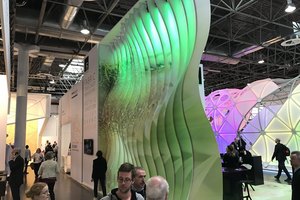 Innovativer Messestand mit beleuchteter, wellenförmiger Struktur