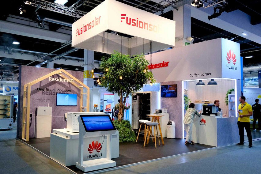 Ein Messestand mit Produkten von FusionSolar und Huawei sowie einem Kaffeebereich.