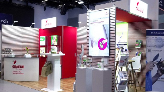 Ein Messestand mit Präsentationsflächen und Informationsmaterialien für Tierprodukte.