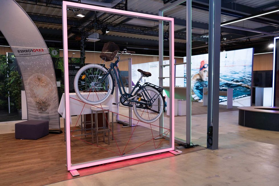 Mit Dekorationskordeln befestigtes Fahrrad als Hingucker am Messerstand