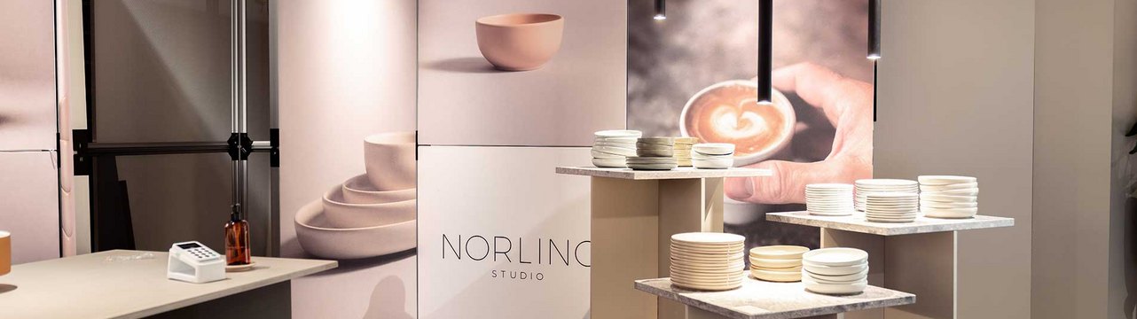 Ein Messestand mit Tischen und Präsentationen von Geschirr und Keramik.