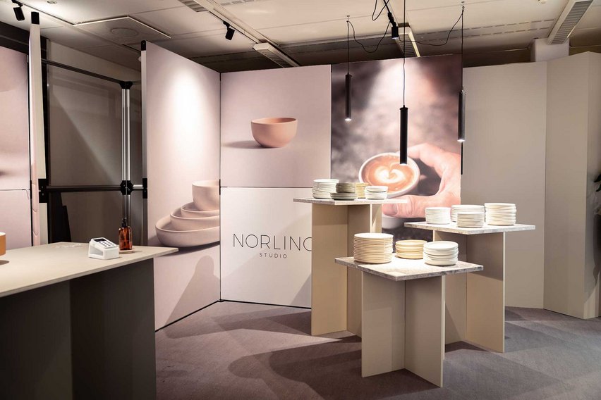 Ein Messestand mit Tischen und Präsentationen von Geschirr und Keramik.