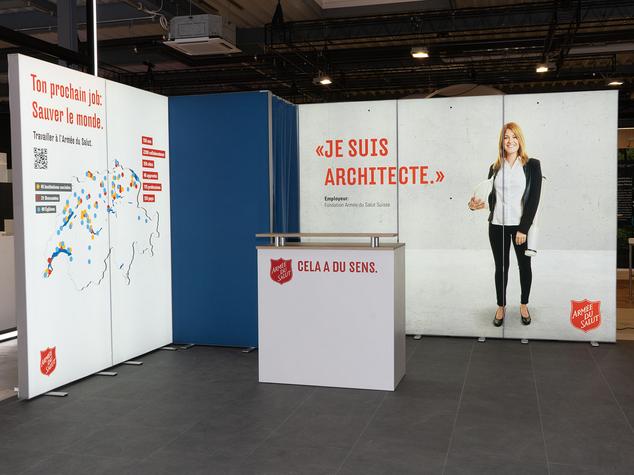 Ein Messestand mit Informationen zur Armee des Saluts und einem Architekten.