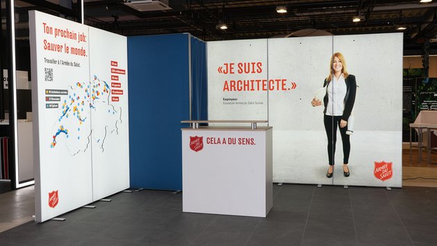 Ein Messestand mit Informationen zur Armee des Saluts und einem Architekten.