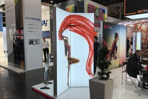 Messestand mit beleuchteten Werbedisplays und Besuchern