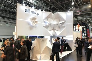 Messestand mit geometrischen Designelementen, Besuchergruppen und Firmenlogo