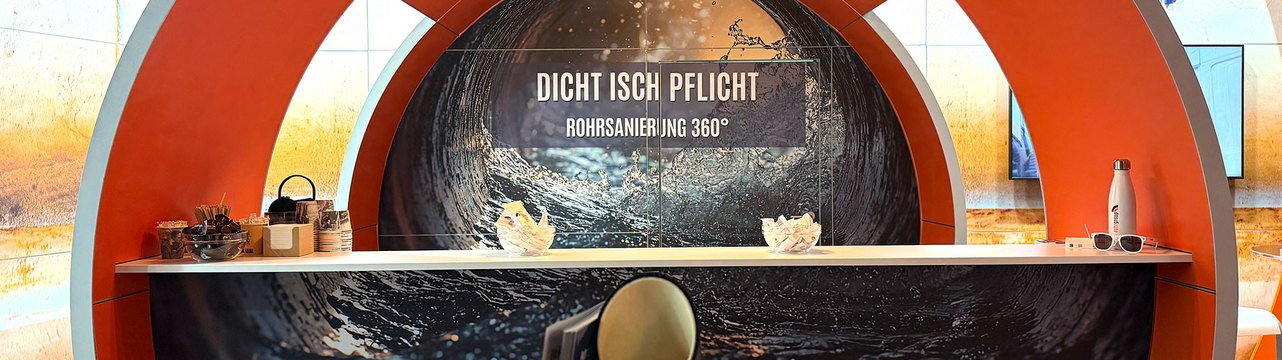 Ein Messestand mit einem runden Design und dem Schriftzug „DICHT ISCH PFLICHT“.