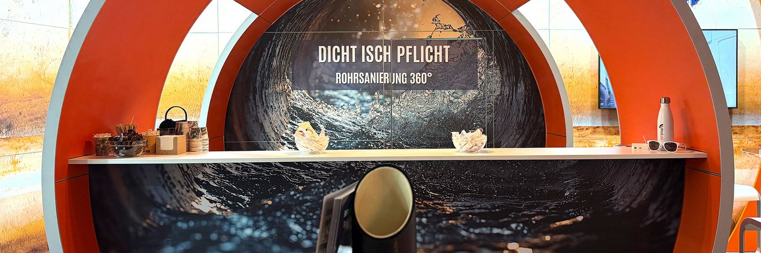 Ein Messestand mit einem runden Design und dem Schriftzug „DICHT ISCH PFLICHT“.