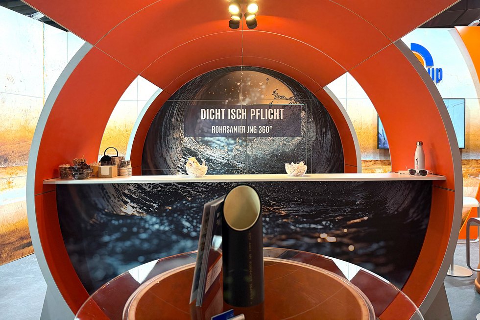 Ein Messestand mit einem runden Design und dem Schriftzug „DICHT ISCH PFLICHT“.