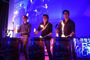 Drei Trommler mit Feuersticks bei einer Performance