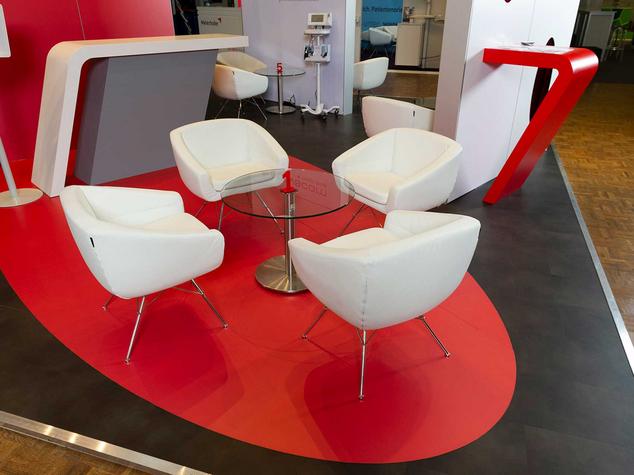 Modern gestalteter Messestand mit Loungemöbeln und Empfangstheke