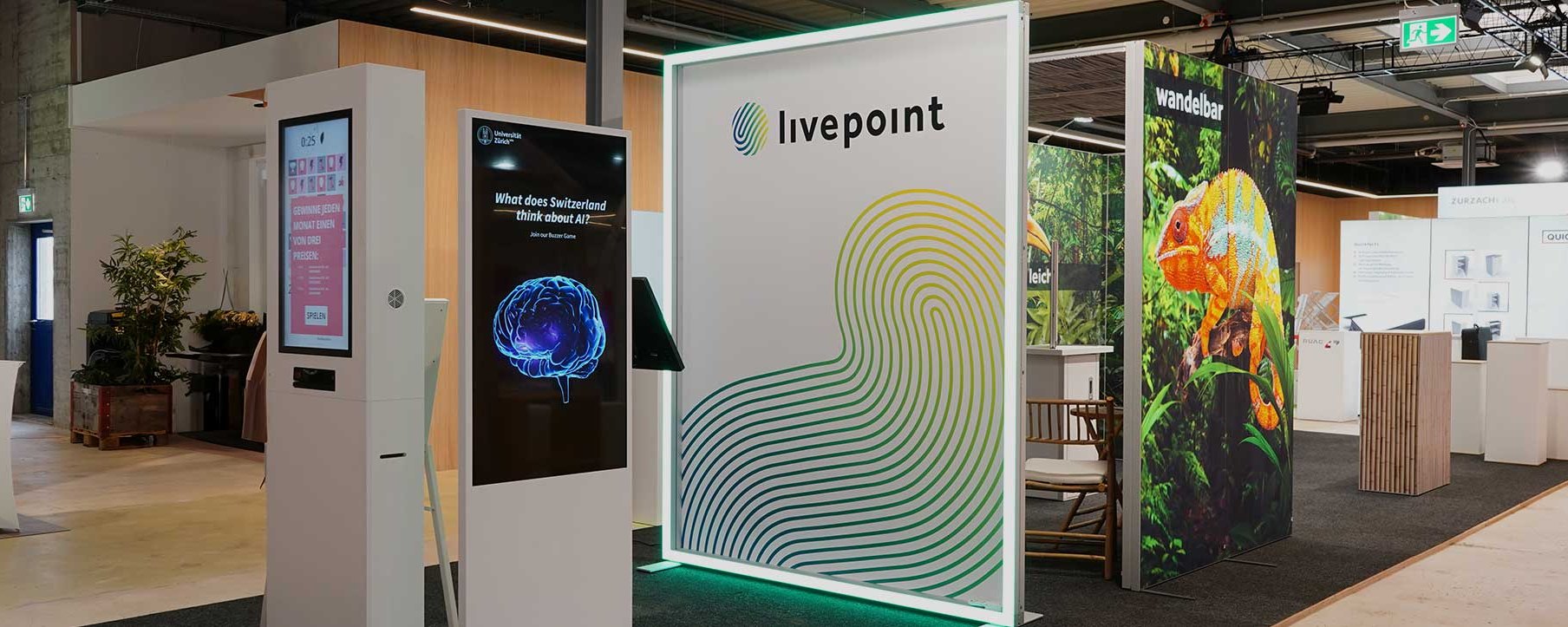 Messestand mit interaktiven Bildschirmen und verschiedenen Displays.