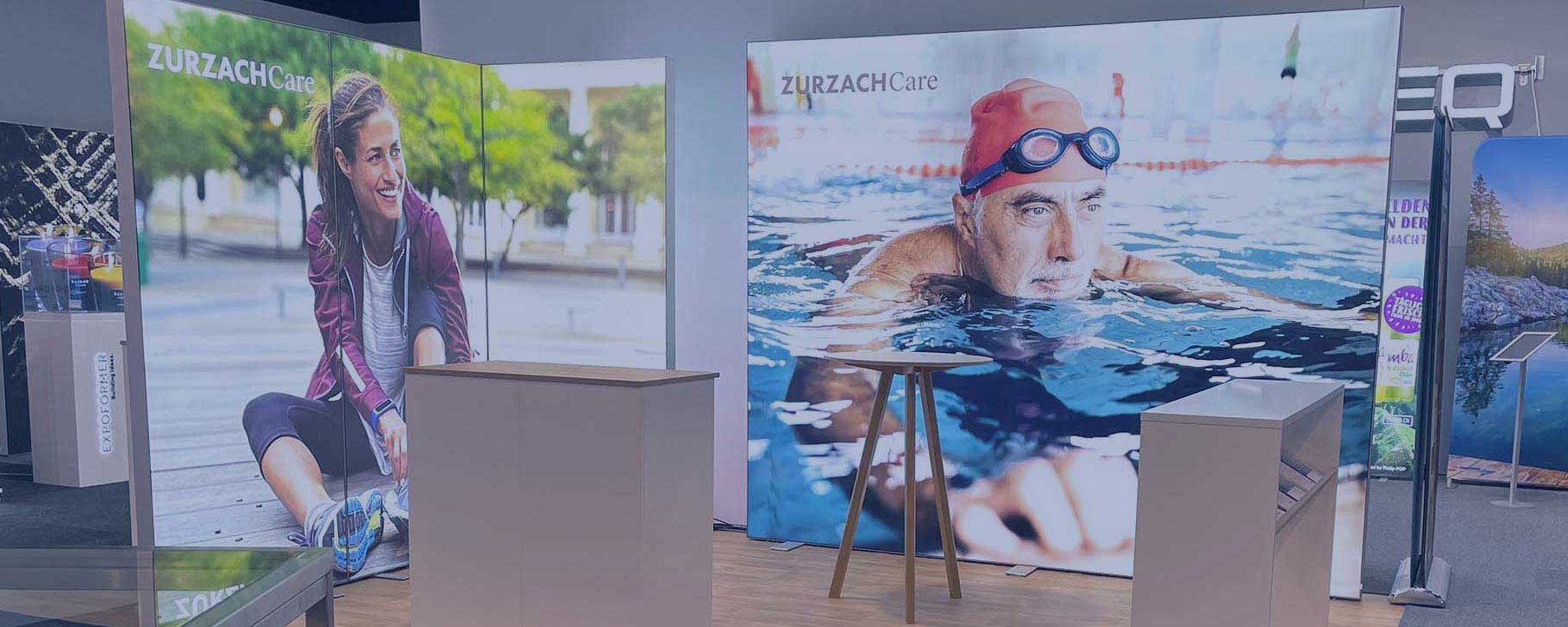 Messestand mit zwei grossen Bildern und Möbeln.