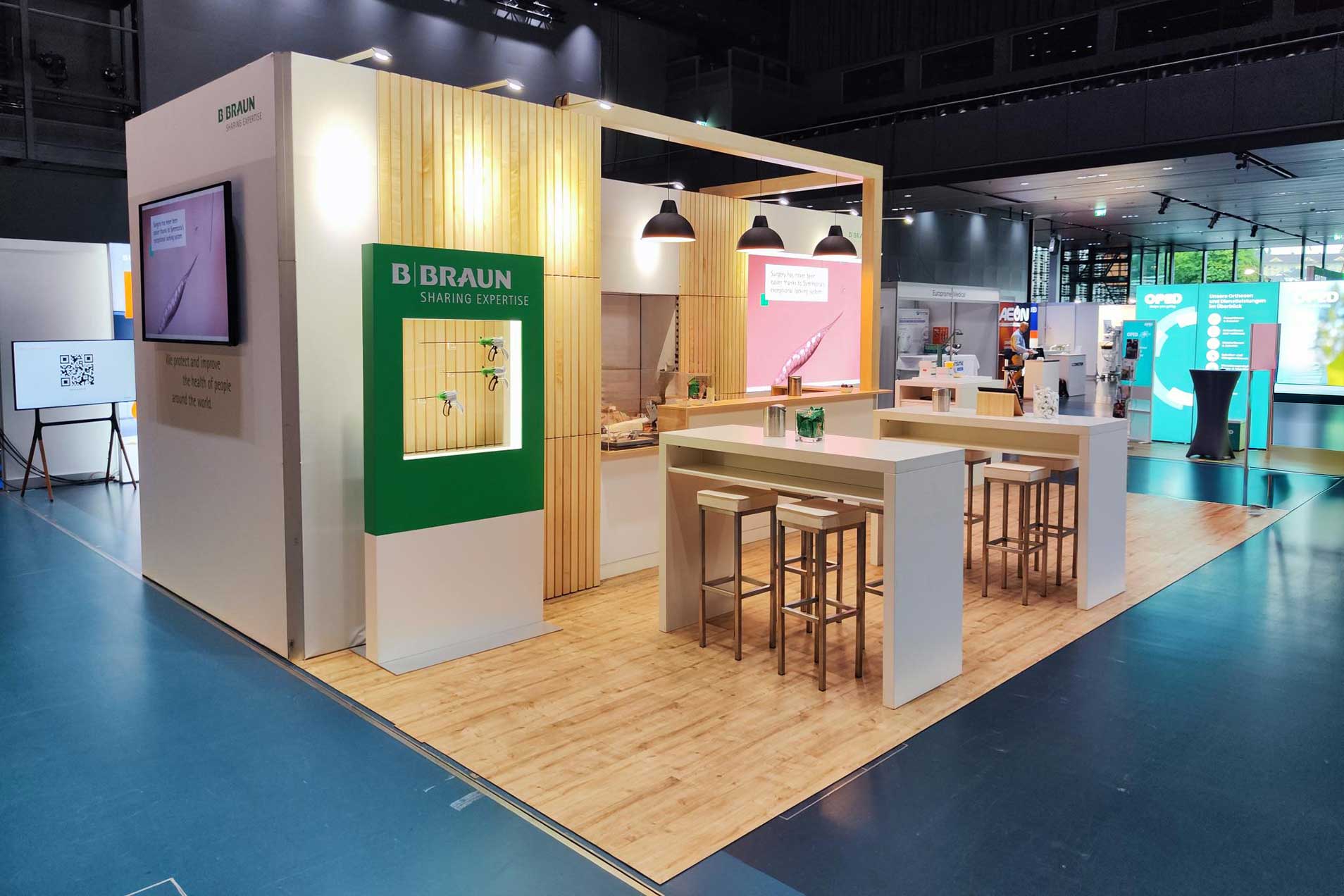 Ein Messestand mit einer Kaffeebar, Sitzgelegenheiten und digitalen Displays.