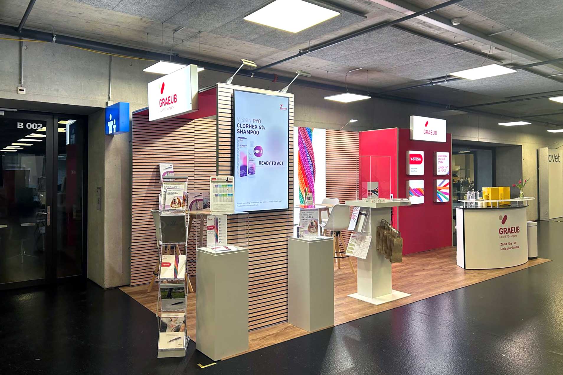 Ein Messestand mit Produkten, Messe Mobiliar und einem Empfangstresen.