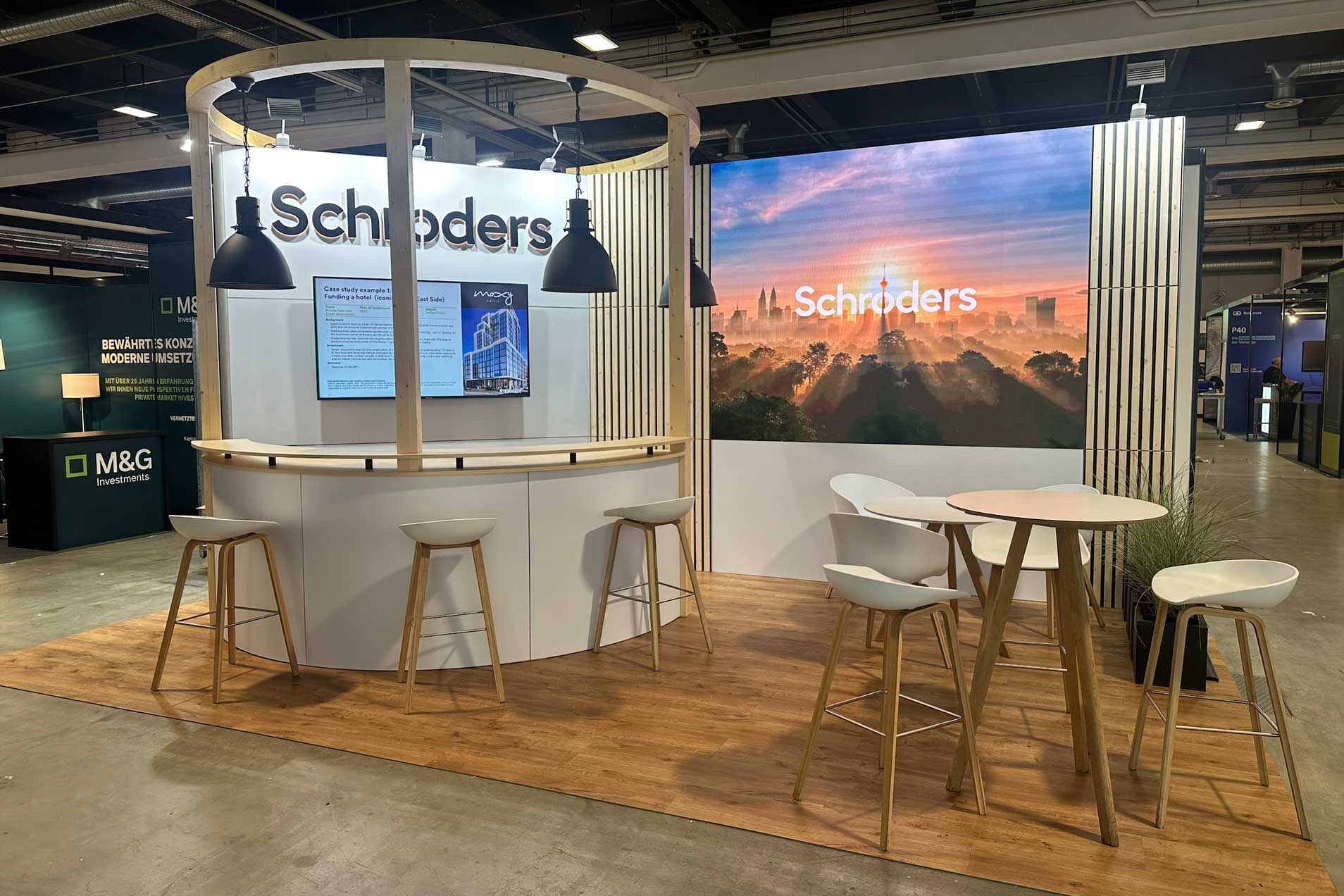 Ein Messestand mit einem Namen und Sitzgelegenheiten.