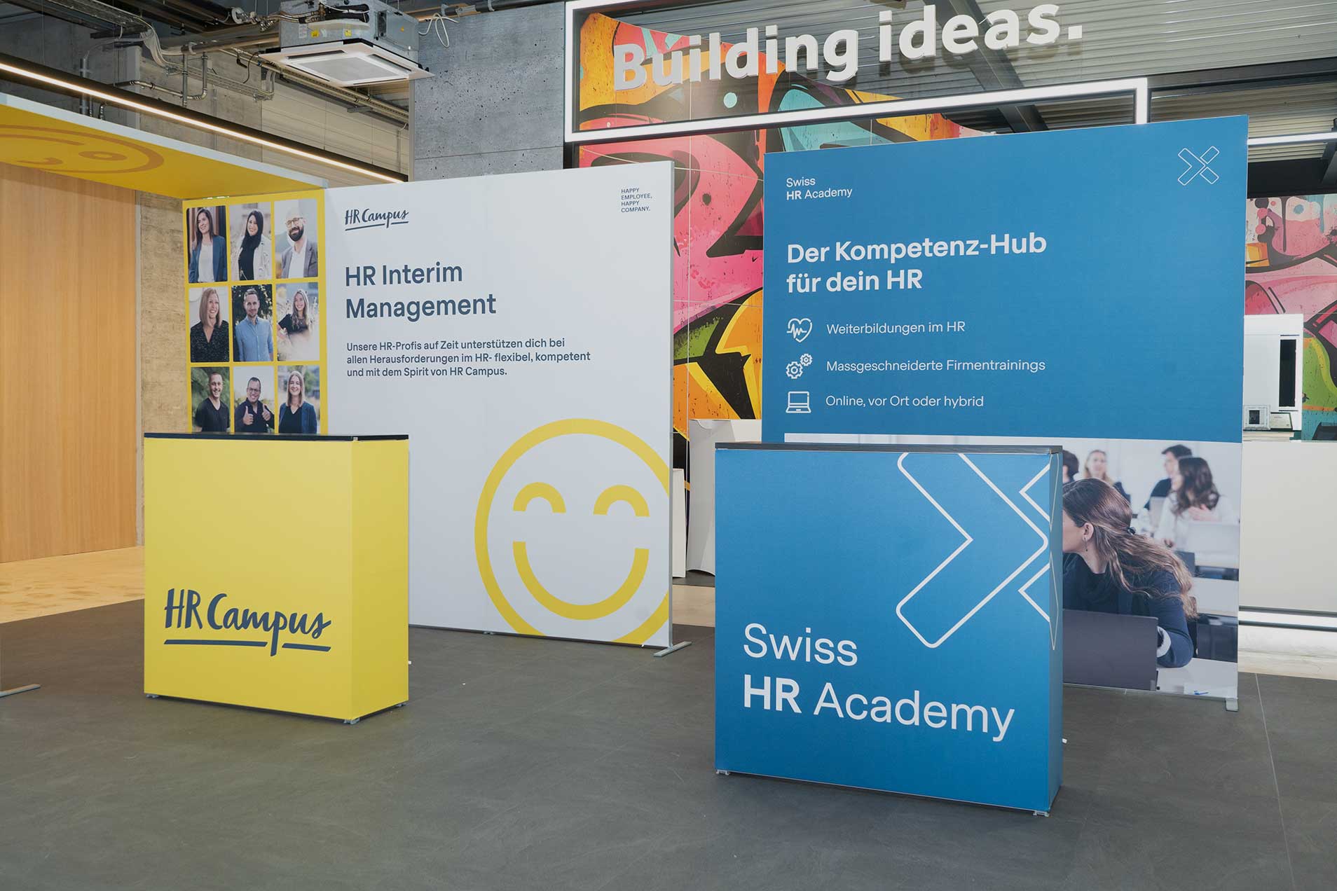 Messestand mit Informationsständen zu HR-Dienstleistungen.
